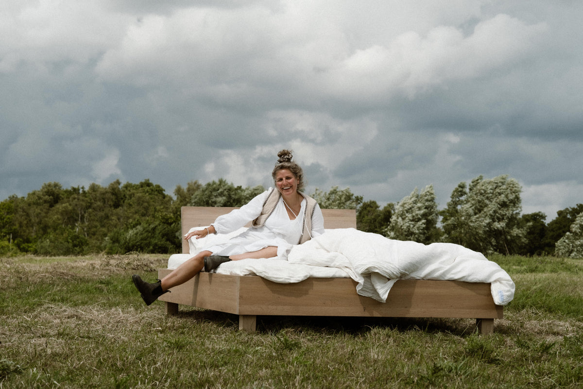Bed in weiland met linnen beddengoed. Natuur in natuur. Alicja